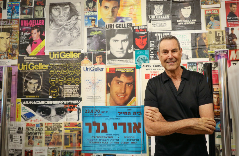 URI GELLER stands by a wall of posters, flyers and headlines documenting the many highlights of his career. (credit: MARC ISRAEL SELLEM/THE JERUSALEM POST)