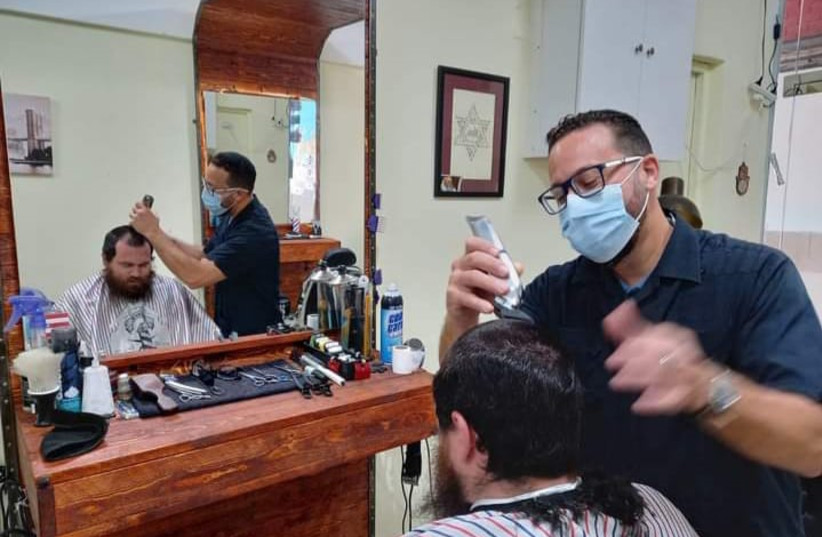  Yosef Maldonado is seen working at his barbershop. (photo credit: Courtesy Yosef Maldonado)