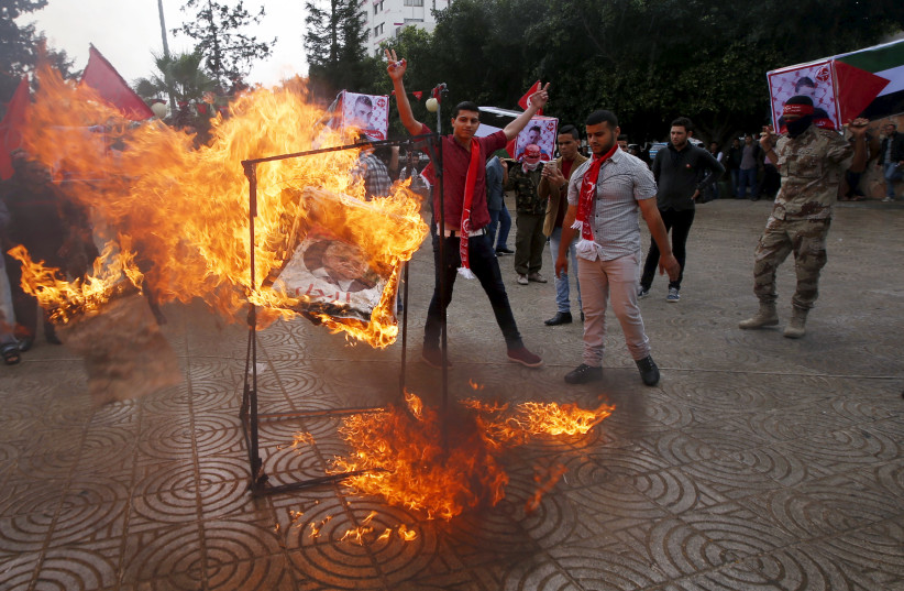  Supporters of the Popular Front for the Liberation of Palestine (PFLP) burn a poster of Palestinian President Mahmoud Abbas during a protest against Abbas's policies, in Gaza City April 12, 2016.  (photo credit: REUTERS/MOHAMMED SALEM)