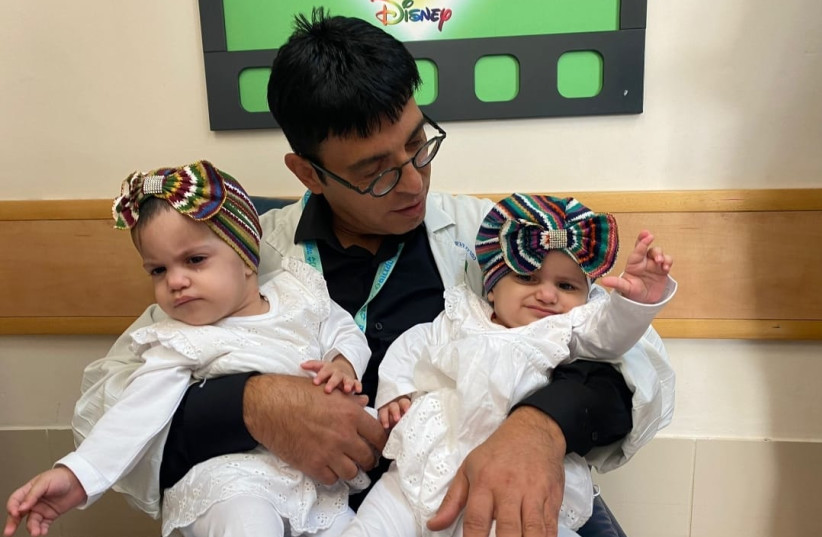  Dr. Mickey Gideon Director of Pediatric Neurosurgery at Soroka University Medical Center and one of the lead surgeons of the operation, with the twins. (photo credit: Courtesy)