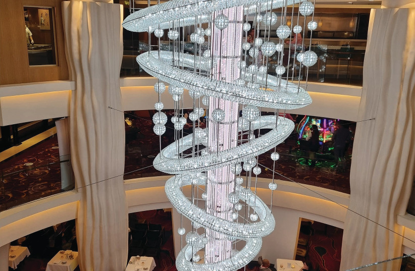 An ornate chandelier hangs in the middle of the ship, giving guests a sense of the luxury that awaits them on board. (credit: NOA AMOUYAL)