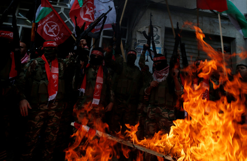  Palestinian militants of the Popular Front for the Liberation of Palestine (PFLP) burn representations of an Israeli flag and a US flag during a protest against Trump's decision to recognize Jerusalem as the capital of Israel, in Gaza City December 7, 2017.  (photo credit: REUTERS/MOHAMMED SALEM)
