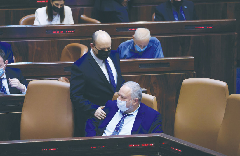 Prime Minister Naftali Bennett with Finance Minister Avigdor Liberman during a vote on the state budget in the Knesset last month. (credit: OLIVIER FITOUSSI/FLASH90)