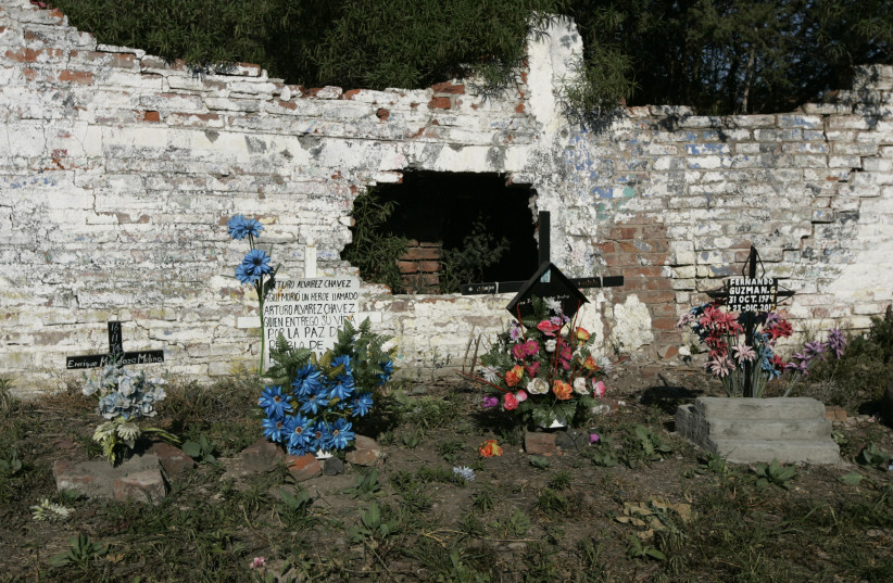  Plastic flowers are seen at crosses set up in memory of four policemen who were killed a year ago in a shoot-out with alleged gang members in La Barca November 27, 2013. (photo credit: REUTERS/ALEJANDRO ACOSTA)