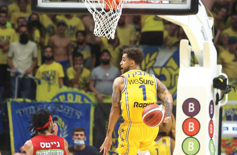  MACCABI TEL AVIV guard Scottie Wilbekin delivers a nifty behind-the-back pass during the yellow-and-blue’s 104-80 conquest of Hapoel Jerusalem over the weekend. (photo credit: DANNY MARON)