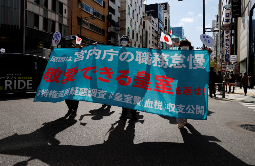  Protesters hold banners during a march against the marriage between Japan's Princess Mako and her fiance Kei Komuro in Tokyo, Japan, October 26, 2021. The slogan in the read reads, 'Bring back an imperial family where we can love and respect' (credit:  REUTERS/KIM KYUNG-HOON)