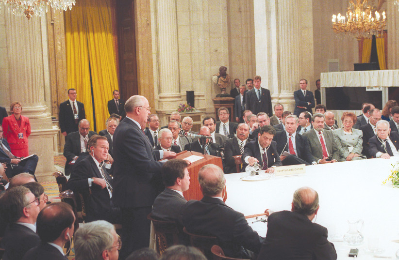 THEN-SOVIET PRESIDENT Mikhail Gorbachev addresses the first meeting of the Mideast peace conference in Madrid on October 30, 1991. Alongside Gorbachev is US President George Bush. At far right is prime minister Yitzhak Shamir. (photo credit: JIM HOLLANDER/REUTERS)