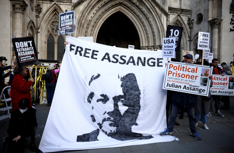  Supporters of Wikileaks founder Julian Assange display signs and banners as they protest outside the Royal Courts of Justice in London, Britain, October 28, 2021 (photo credit: REUTERS/HENRY NICHOLLS)