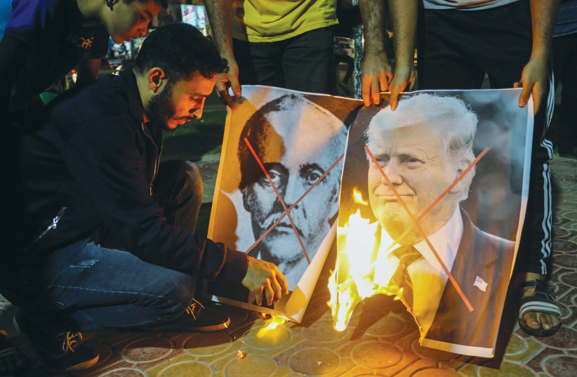 PALESTINIANS IN RAFAH burn posters of former US president Donald Trump and Arthur James Balfour during a protest last year on the anniversary of the Balfour Declaration. (photo credit: ABED RAHIM KHATIB/FLASH90)