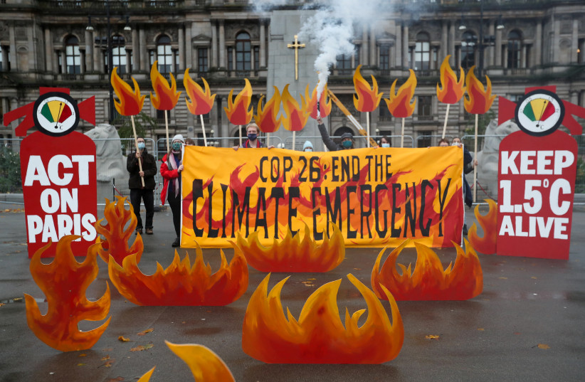  Activists symbolically set George Square on fire with an art installation of faux flames and smoke ahead of the UN Climate Change Conference (COP26), in Glasgow, Scotland, Britain October 28, 2021.  (photo credit: REUTERS/RUSSELL CHEYNE)