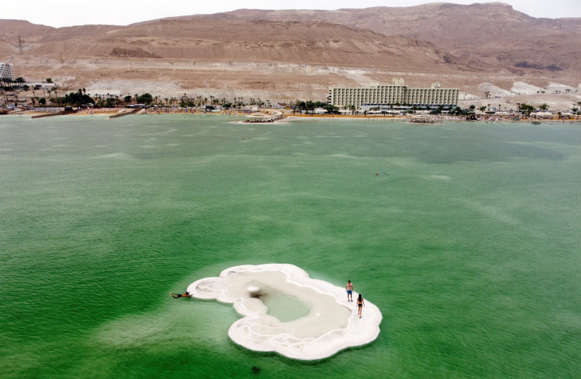  Visitors explore a salt formation in the Dead Sea near Ein Bokek, Israel October 30, 2021 (credit: REUTERS/AMIR COHEN)
