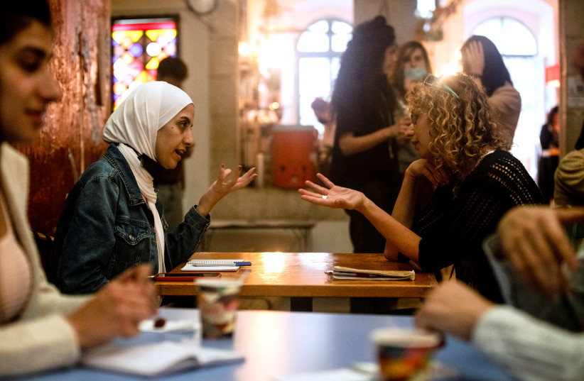  Palestinian woman chats with Israeli woman during language exchange program modelled on speed dating in, Jerusalem (photo credit: RONEN ZVULUN/REUTERS)