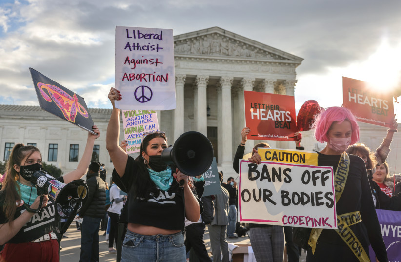 Pro-choice and anti-abortion both demonstrate outside the United States Supreme Court as the court hears arguments over a challenge to a Texas law that bans abortion after six weeks in Washington, US, November 1, 2021. (photo credit: REUTERS/EVELYN HOCKSTEIN)