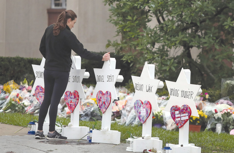  A WOMAN visits a makeshift memorial outside Tree of Life Congregation in Pittsburgh the day after the massacre in October, 2018. (photo credit: CATHAL MCNAUGHTON/REUTERS)