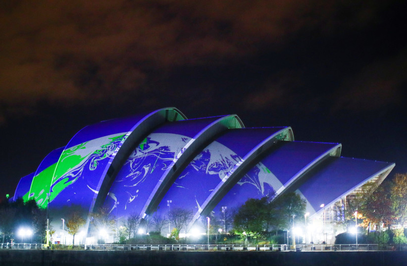  An image of Earth is projected on the venue for COP26 summit in Glasgow, Scotland Britain, November 1, 2021. (photo credit: REUTERS/HANNAH MCKAY)