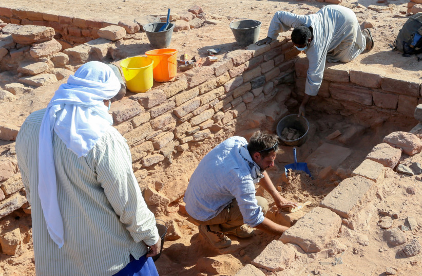   Seorang arkeolog Prancis dan rekan kerjanya dengan hati-hati membersihkan tembikar untuk memeriksa temuan yang diketahui berasal dari peradaban Dadan dan Lihyan yang berasal dari paruh kedua milenium pertama SM, di Al-Ula, Arab Saudi 30 Oktober 2021 (kredit: AHMED YOSRI/REUTERS)