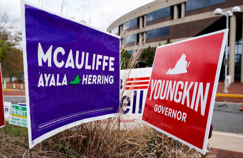 Campaign signs for Democrat Terry McAuliffe and Republican Glenn Youngkin stand together on the last day of early voting in the Virginia gubernatorial election in Fairfax, Virginia, October 30, 2021 (photo credit: JOSHUA ROBERTS / REUTERS)