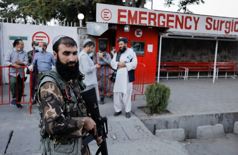  An armed member of Taliban forces stands outside an emergency hospital, after several civilians were killed in an explosion, in Kabul, Afghanistan, October 3, 2021 (credit: JORGE SILVA / REUTERS)