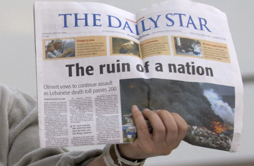  David Merhige of New York, evacuated by the United States from Lebanon, holds a copy of The Daily Star newspaper with the headline "The Ruin of a Nation", 2006 (photo credit: REUTERS)