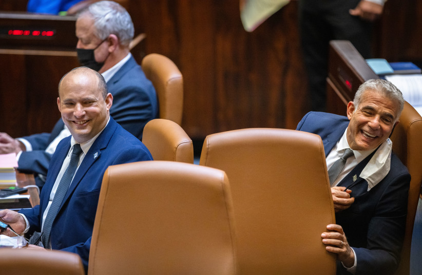  Prime Minister Naftali Bennett and Foreign Minister Yair Lapid seen during a plenum session and a vote on the state budget at the assembly hall of the Israeli parliament, in Jerusalem on November 3, 2021.  (credit: OLIVIER FITOUSSI/FLASH90)