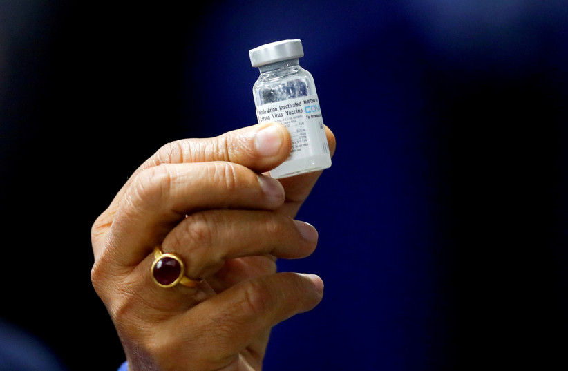 Indian Health Minister Harsh Vardhan holds a dose of Bharat Biotech's COVID-19 vaccine called COVAXIN, during a vaccination campaign at All India Institute of Medical Sciences (AIIMS) hospital in New Delhi, India, January 16, 2021.  (photo credit: REUTERS/ADNAN ABIDI)