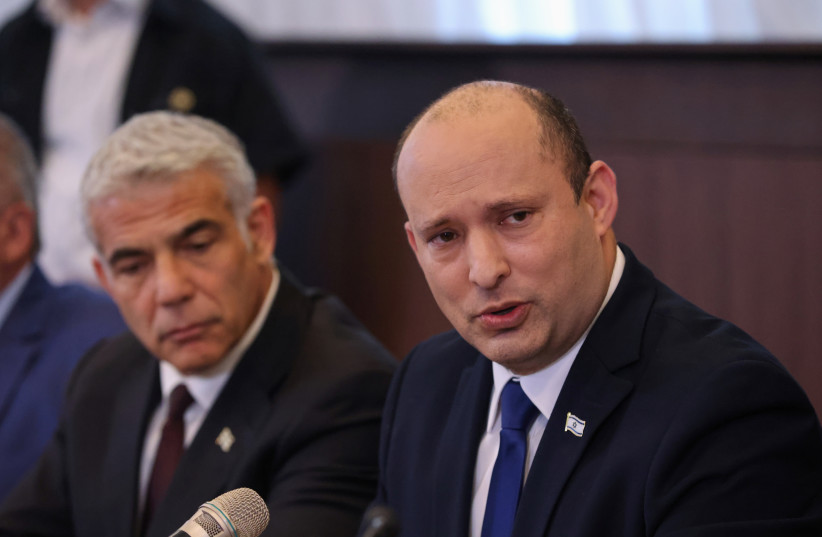  Israeli Prime Minister Naftali Bennett sits next to alternate Prime Minister and Foreign Minister Yair Lapid as he speaks during the first weekly cabinet meeting of his new government in Jerusalem June 20, 2021. (credit: EMMANUEL DUNAND/POOL VIA REUTERS)