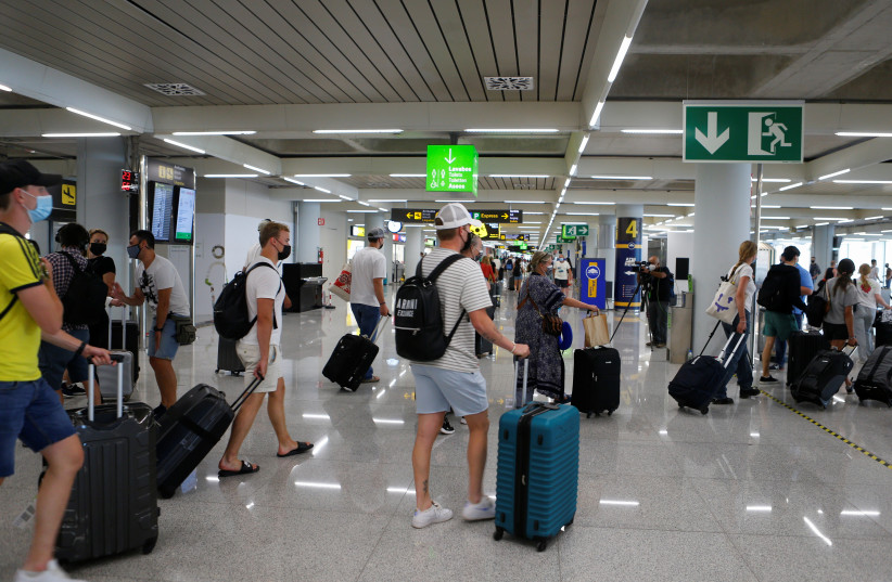 Tourists from Britain arrive at Palma de Mallorca Airport following London's lifted quaraintine requirements for travellers returning from the Balearic Islands, amid the coronavirus disease (COVID-19) pandemic, in Palma de Mallorca, Spain June 30, 2021. (credit: REUTERS/ENRIQUE CALVO)