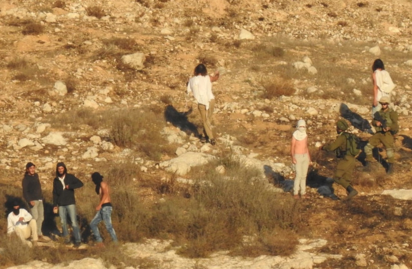  Israeli settlers clash with Palestinians after throwing stones at houses on the edge of the Palestinian village of Burin, November 6, 2021 (credit: YESH DIN)