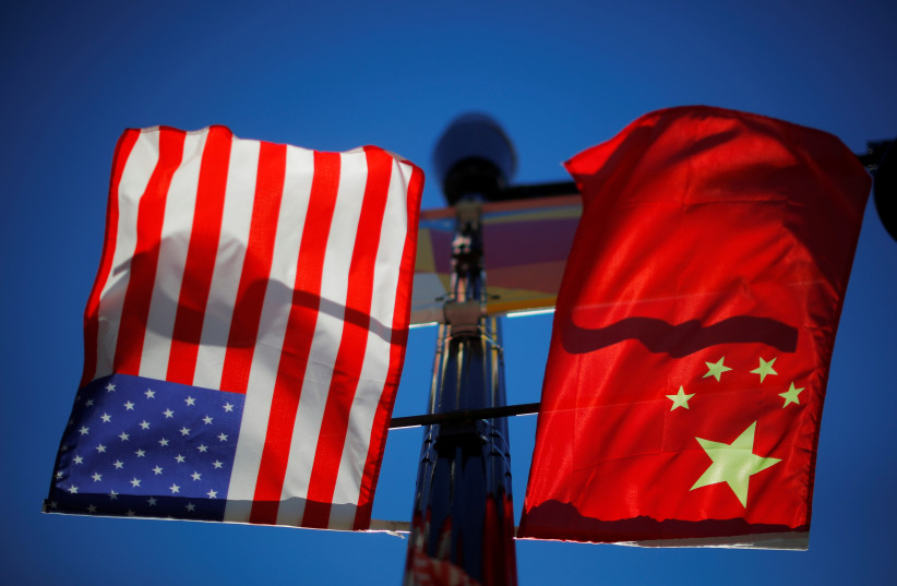 Les drapeaux des États-Unis et de la Chine flottent depuis un lampadaire dans le quartier chinois de Boston, Massachusetts, États-Unis, le 1er novembre 2021. (crédit : REUTERS/BRIAN SNYDER)
