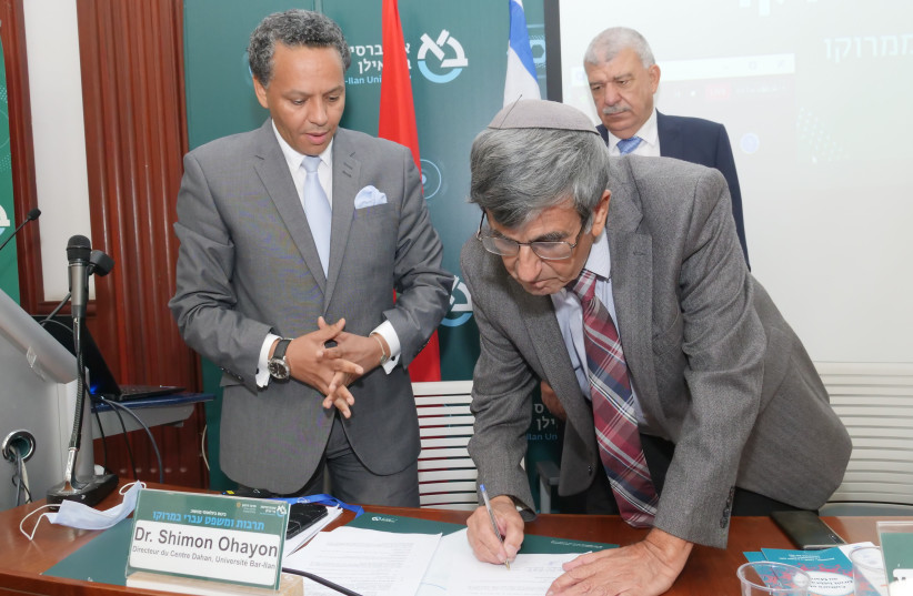 Dr. Shimon Ohayon signs the agreement as Dr. Abdellah Ouzitane (left) and Mr. Abderrahim Beyyoud look on (photo credit: PELEG LEVY)