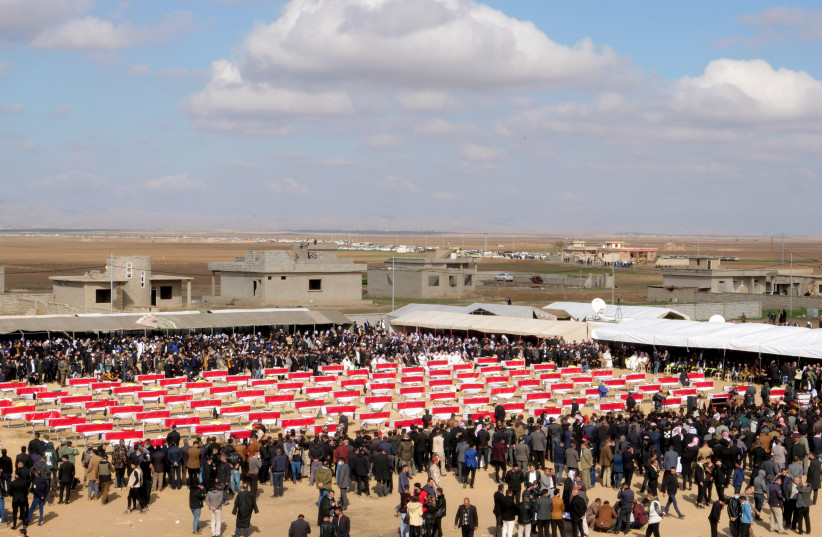  Coffins with remains of people from the Yazidi minoirty, who were killed by Islamic State militants, and they were exhumed from a mass grave, are seen during the funeral in Kojo, Iraq February 6, 2021.Picture taken February 6, 2021. (photo credit: REUTERS/CHARLOTTE BRUNEAU)