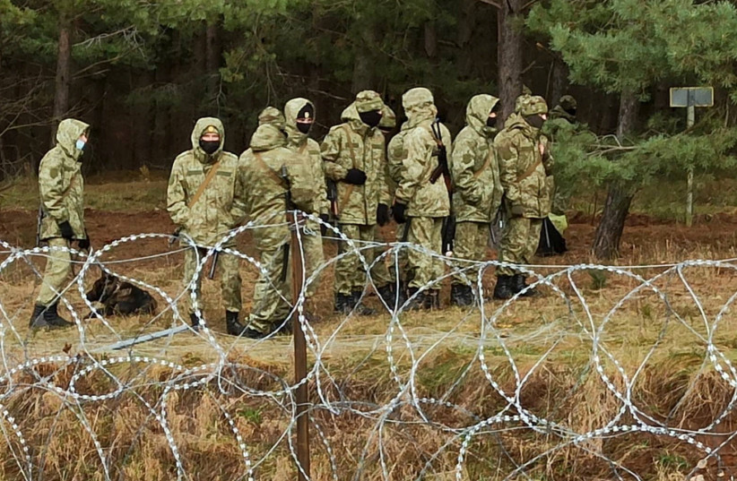Belarusian soldiers patrol the border as hundreds of migrants try to cross from the Belarus side of the border with Poland near Kuznica Bialostocka, Poland, in this video-grab released by the Polish Defence Ministry, November 8, 2021. (photo credit: MON/HANDOUT VIA REUTERS)
