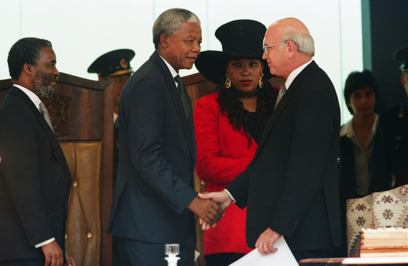  Nelson Mandela the first black newly appointed President of South Africa, shakes hands with the outgoing President Frederik Willem de Klerk, the seventh and last State President of apartheid-era South Africa, as Vice President Thabo Mbeki looks on, at the Union Buildings in Pretoria, May 1994 (credit: REUTERS/PETER ANDREWS)