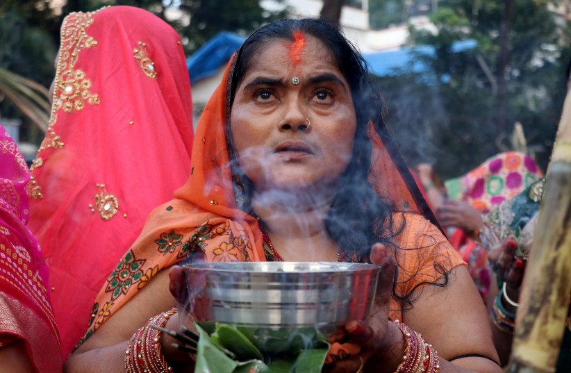  A Hindu woman worships the Sun god in an artificial pond during the religious festival of Chhath Puja in Mumbai, India, November 10, 2021.  (credit: REUTERS/NIHARIKA KULKARNI)