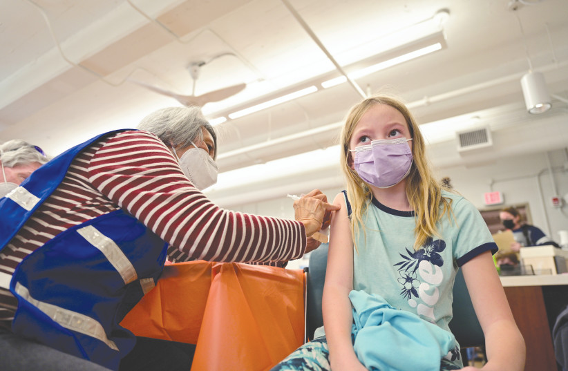 A YOUNG GIRL receives a dose of the Pfizer-BioNTech COVID-19 vaccine in Louisville, Kentucky, earlier this week. Will we be seeing similar scenes in Israel soon? (photo credit: Jon Cherr/Reuters)