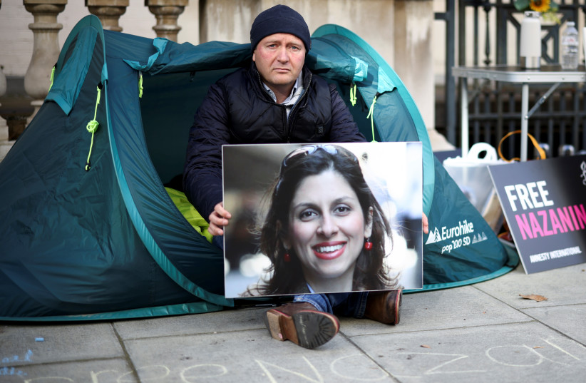  Richard Ratcliffe, husband of British-Iranian aid worker Nazanin Zaghari-Ratcliffe, poses with a photo of his wife during a second hunger strike, outside the Foreign, Commonwealth and Development Office (FCDO) in London, Britain October 25, 2021. (photo credit: HENRY NICHOLLS/REUTERS)