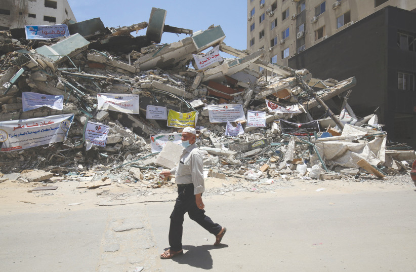  A MAN WALKS past destruction in Gaza following the aftermath of May’s 11-day war between Israel and Hamas. (credit: ABED RAHIM KHATIB/FLASH90)