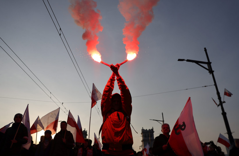  Un manifestant brûle des fusées éclairantes lors d'une marche marquant la fête nationale de l'indépendance à Varsovie, en Pologne, le 11 novembre 2021. (Crédit photo : MARTYNA NIECKO/AGENCJA WYBORZCA.PL VIA REUTERS)