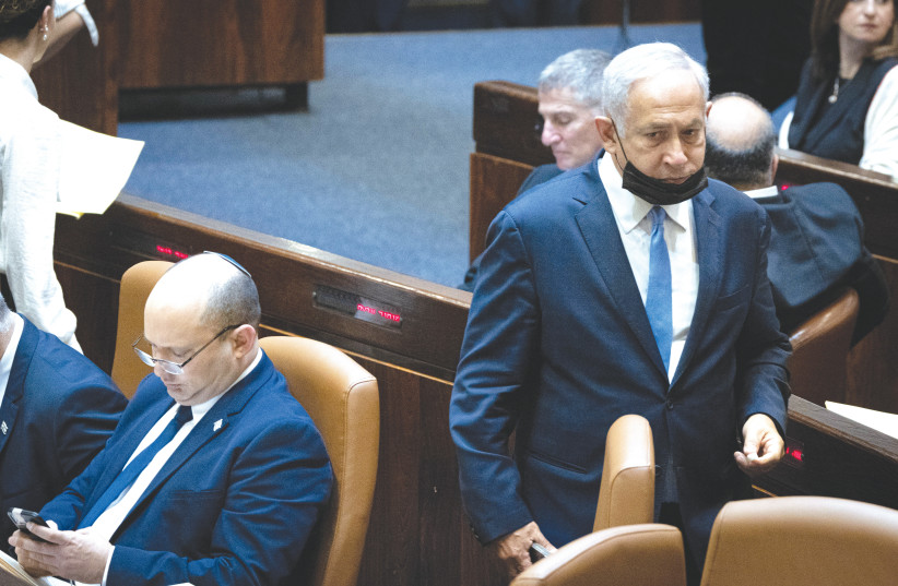 Opposition leader Benjamin Netanyahu walks behind Prime Minister Naftali Bennett in the Knesset earlier this month. (photo credit: YONATAN SINDEL/FLASH90)