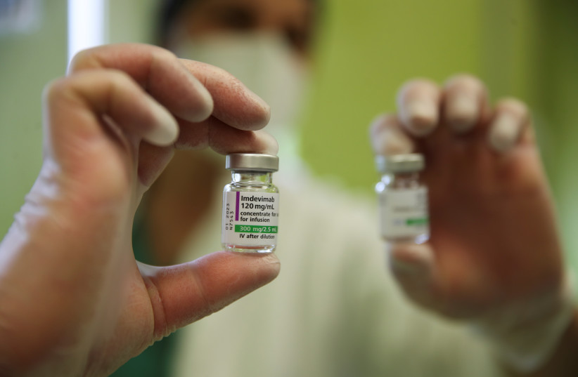  A health worker holds up a vial of Imdevimab, an antibody cocktail designed to produce resistance to the coronavirus disease (COVID-19), at San Giuseppe Hospital, in Albano, Italy, April 22, 2021 (photo credit: REUTERS/YARA NARDI)