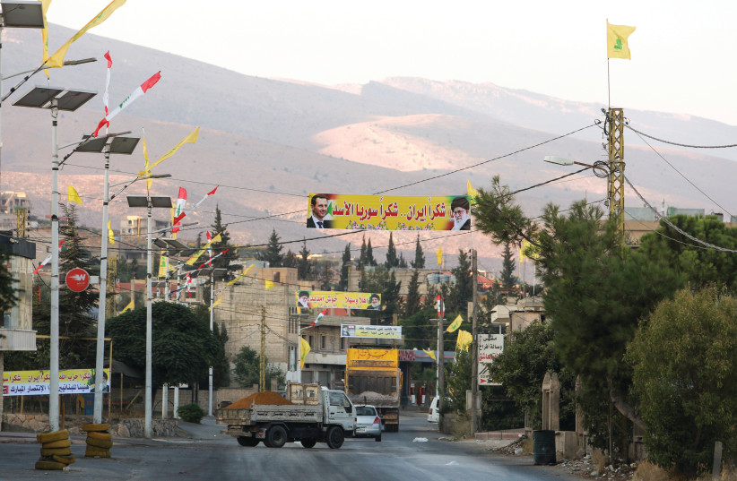  A ROAD is decorated with banners depicting Syria’s President Bashar Assad, and Iran’s Supreme Leader Ayatollah Ali Khamenei in the Lebanese village al-Ain, close to the border with Syria. (photo credit: AZIZ TAHER/REUTERS)