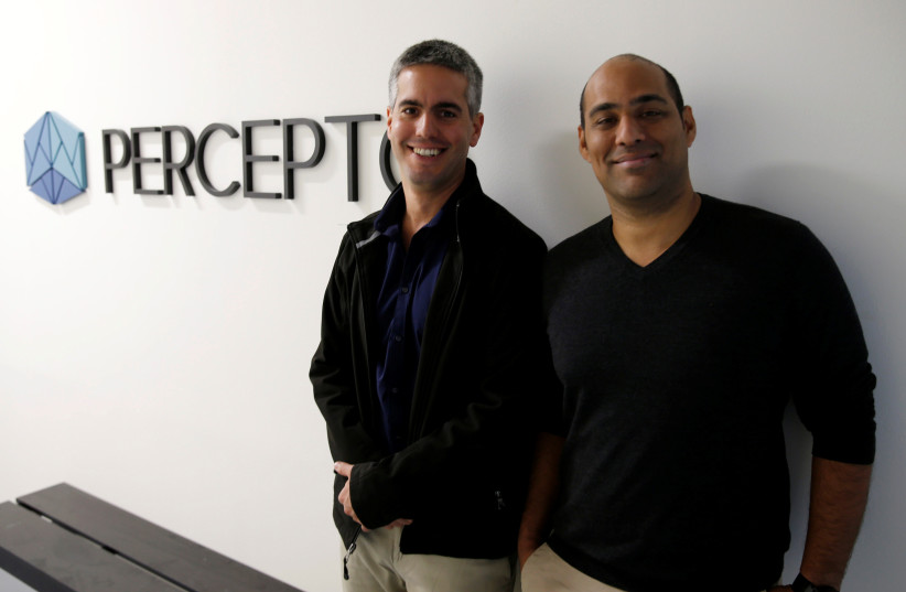 Ariel Avitan (R), Chief Commercial Officer, and Dor Abuhasira, CEO and co-founder of Israeli company Percepto, pose for a photograph next to the company logo at their offices in Modiin, Israel, December 1, 2016. (credit: REUTERS/BAZ RATNER)