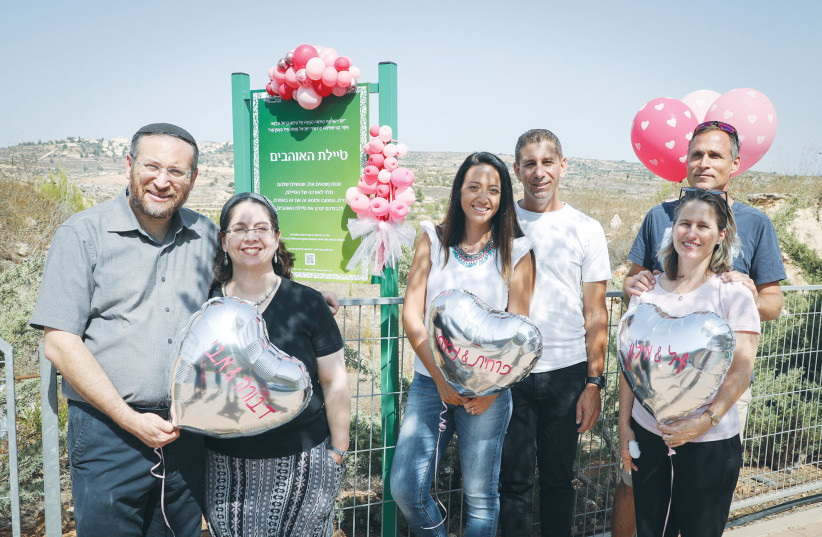  HUSBANDS AND WIVES posing for a photograph taken in 2018 at the newly-constructed Lovers Promenade in Efrat, built in honor of the many couples who have met and married in the city. (photo credit: GERSHON ELINSON/FLASH90)