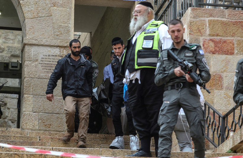  Israeli security personnel carry a dead body down the steps following a shooting incident in Jerusalem's Old City November 21, 2021. (photo credit: AMMAR AWAD/REUTERS)