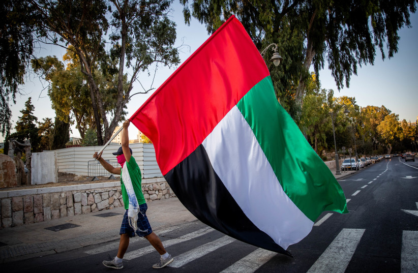  A MAN waves a giant UAE flag  outside the US ambassador’s  residence in Jerusalem, August 19,  2020. (photo credit: YONATAN SINDEL/FLASH90)