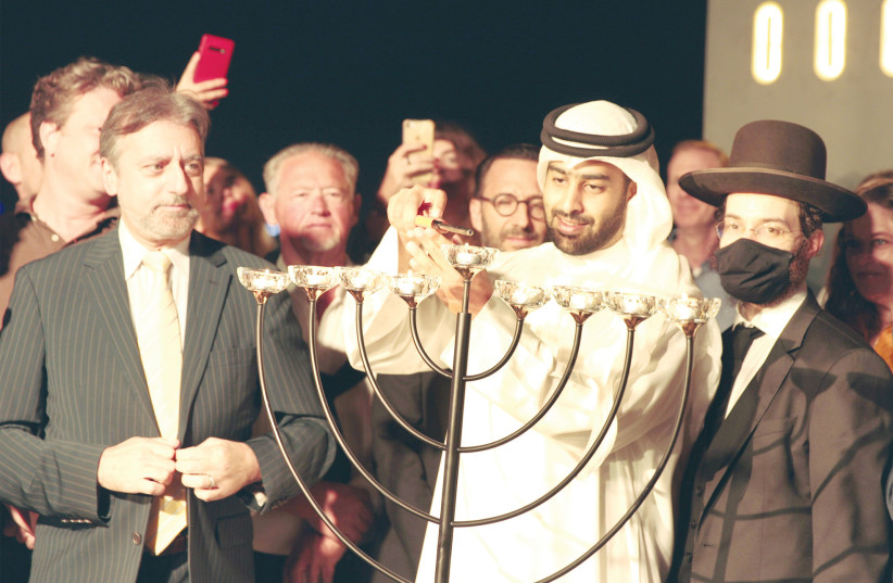  CANDLE LIGHTING at the Jewish Council of the Emirates’ Hanukkah party last year, with the participation of Hamdan Al Kindi of AC (Abrahams Consultancy) Partners, considered a close friend of the Jewish community, with Elie Abadie, senior rabbi of the Jewish Council (L), looking on.  (photo credit: Jewish Council of the Emirates)