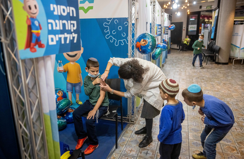  Children aged 5-11 receive their first first dose of Covid-19 vaccine, at Clallit vaccination center in Jerusalem on November 25, 2021. (credit: OLIVIER FITOUSSI/FLASH90)