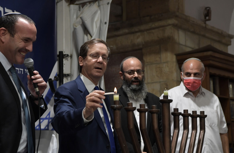President Isaac Herzog President Isaac Herzog lights a menorah on the first night of Hanukkah at the Cave of the Patriarchs in Hebron, November 28, 2021. (photo credit: KOBI GIDEON/GPO)