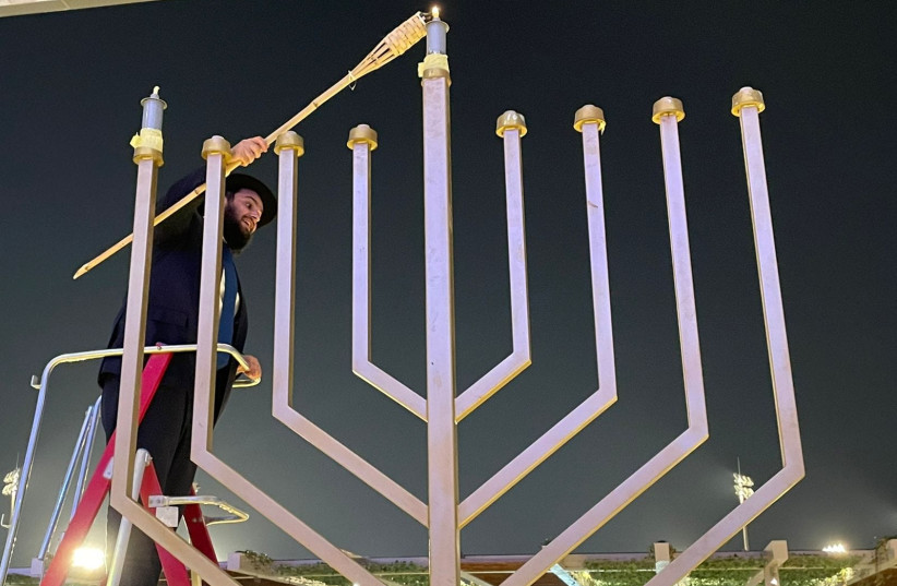  Rabbi Levi Duchman lights the Hanukkah Menorah on November 28th, 2021 at Dubai Expo 2020 in Dubai, UAE. (photo credit: Courtesy JEWISH UAE)