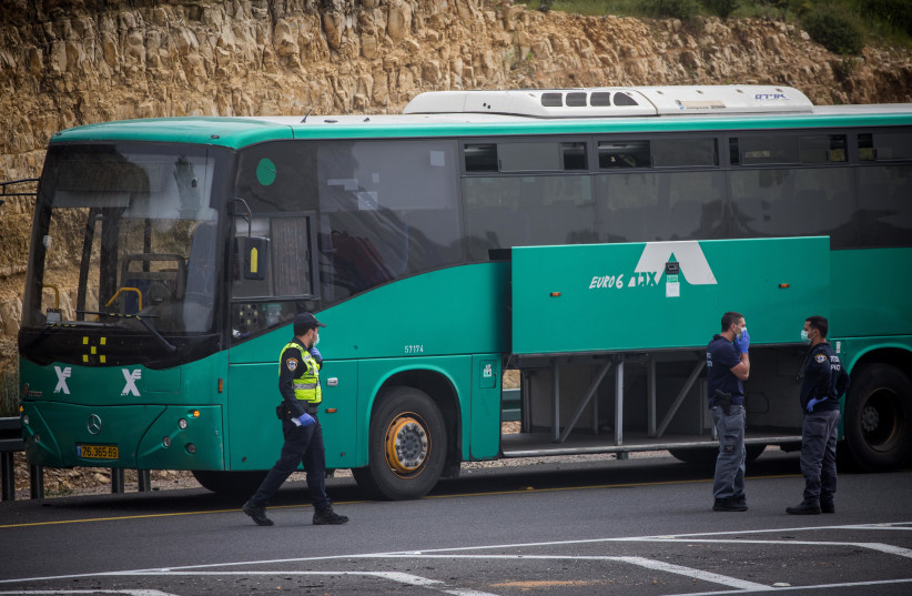  Israeli police officers near Eged Bus on road number 1 near Jerusalem on April 5, 2020, after earlier a man who was tested positive for the coronavirus arrested on the bus.  (photo credit: YONATAN SINDEL/FLASH90)